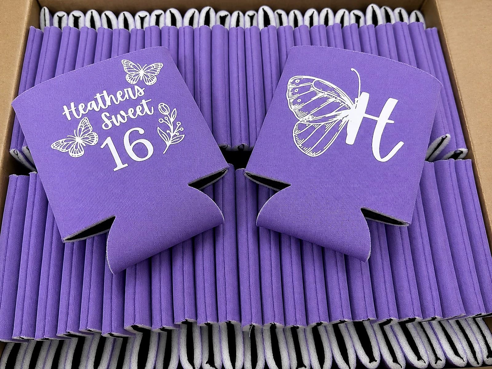 Purple Sweet 16 koozies packed together in a box