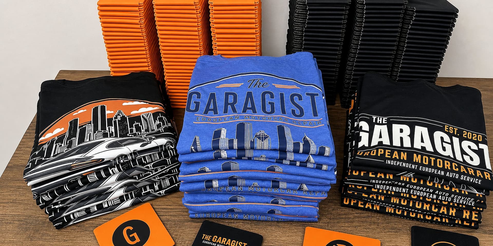 Custom shirts, koozies, stickers, and branded cards arranged together