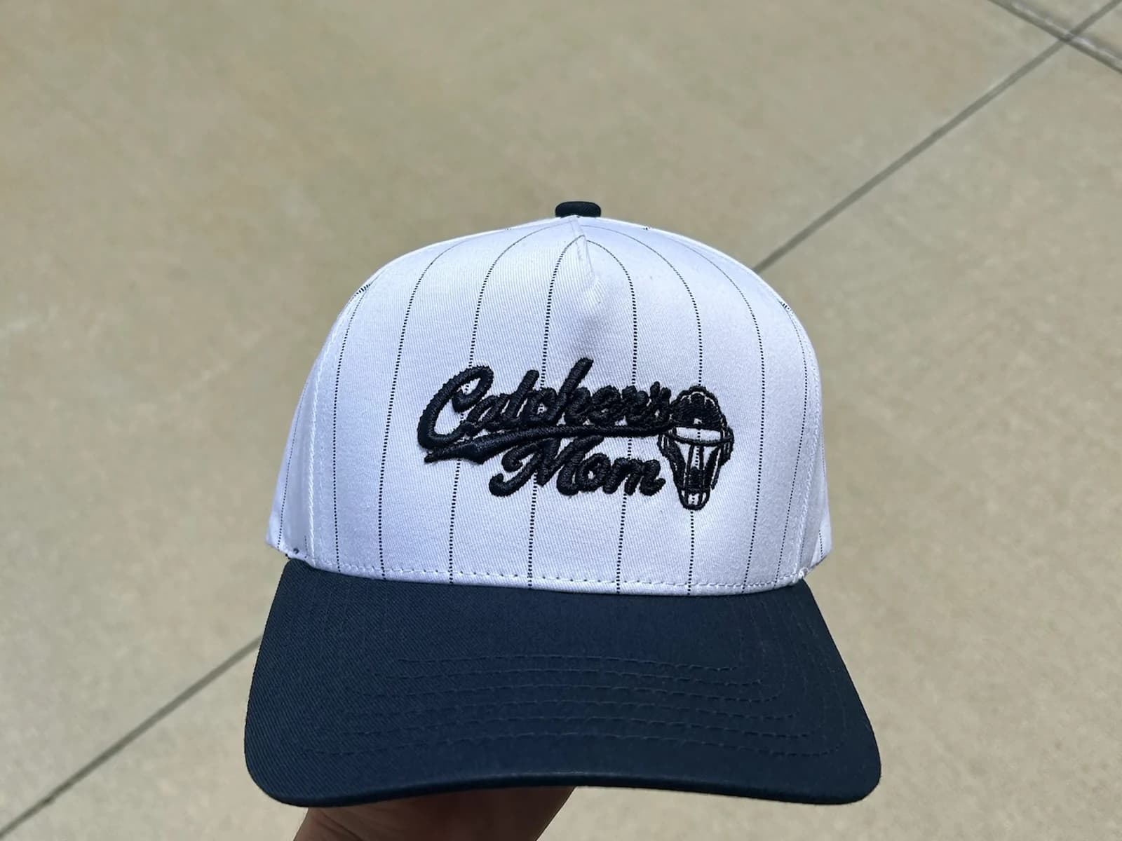 White and black custom embroidered hat displayed outdoors