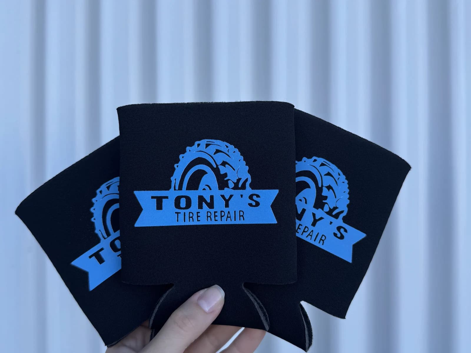 Three black custom koozies printed for Tony's Tire Repair