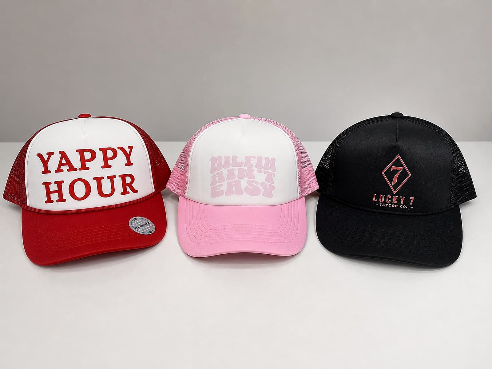 Three custom trucker hats with bold printed designs